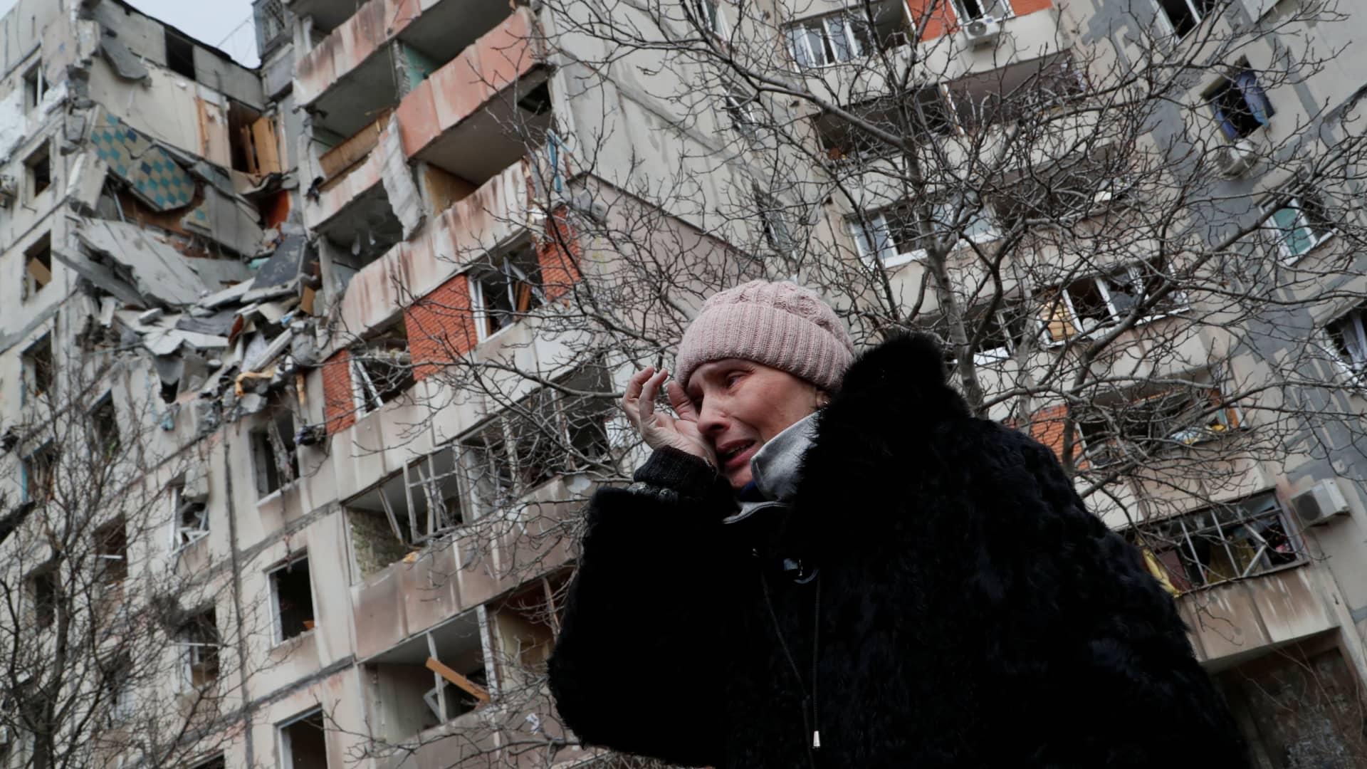 A woman reacts while speaking near a block of flats, which was destroyed during Ukraine-Russia conflict in the besieged southern port city of Mariupol, Ukraine March 17, 2022.