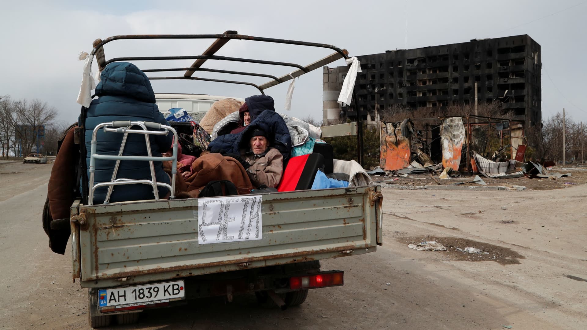 Evacuees fleeing Ukraine-Russia conflict sit in the body of a cargo vehicle while waiting in a line to leave the besieged southern port city of Mariupol, Ukraine March 17, 2022.