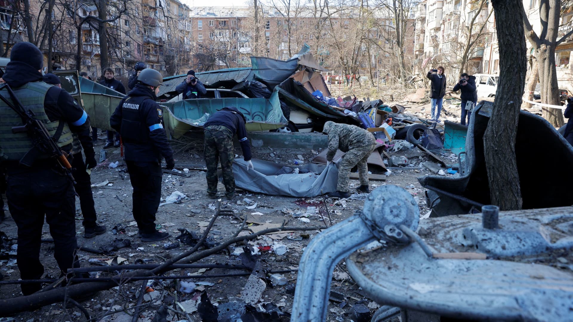 Rescue workers move the body of a person who was killed when a shell hit a residential building, as Russia's invasion of Ukraine continues, in Kyiv, Ukraine March 18, 2022.
