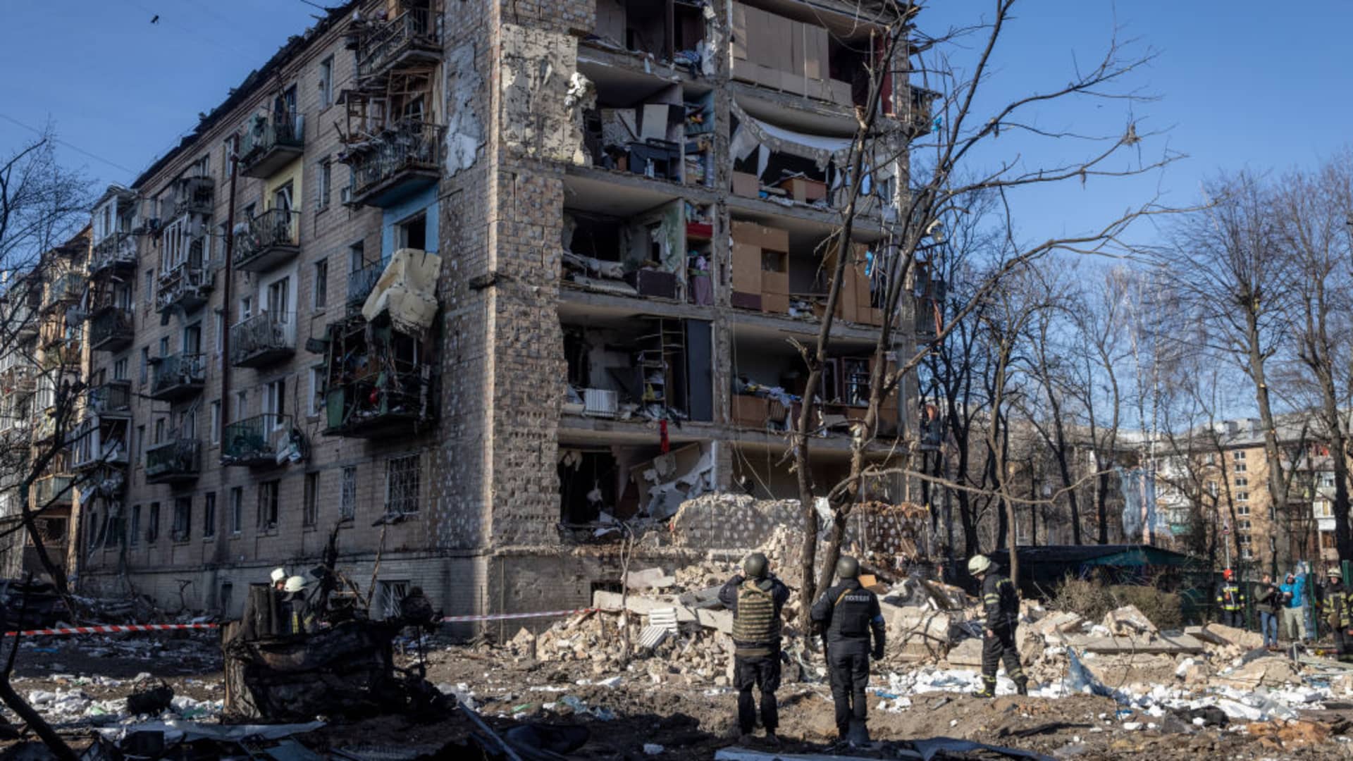 Police and military personnel stand in front of a residential apartment complex that was heavily damaged by a Russian attack on March 18, 2022 in Kyiv, Ukraine.