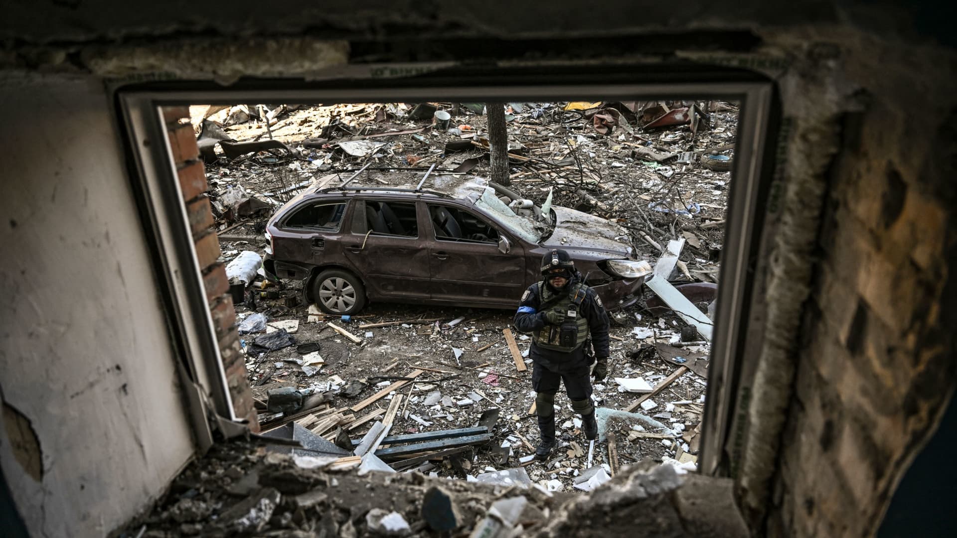 An Ukranian serviceman stands among damages in a residential area after shelling in Kyiv on March 18, 2022, as Russian troops try to encircle the Ukrainian capital as part of their slow-moving offensive.