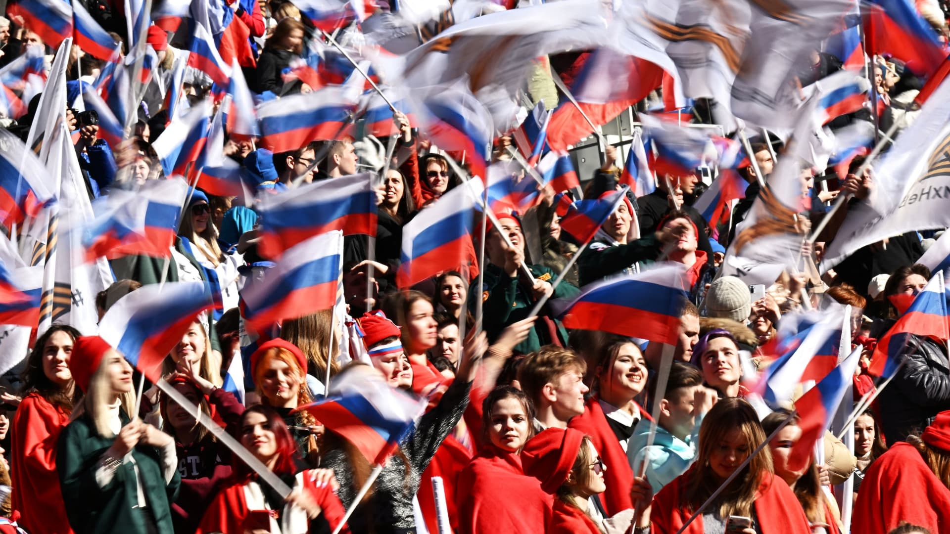 People wave Russian flags during a concert marking the eighth anniversary of Russia's annexation of Crimea at Luzhniki Stadium in Moscow, Russia March 18, 2022. 