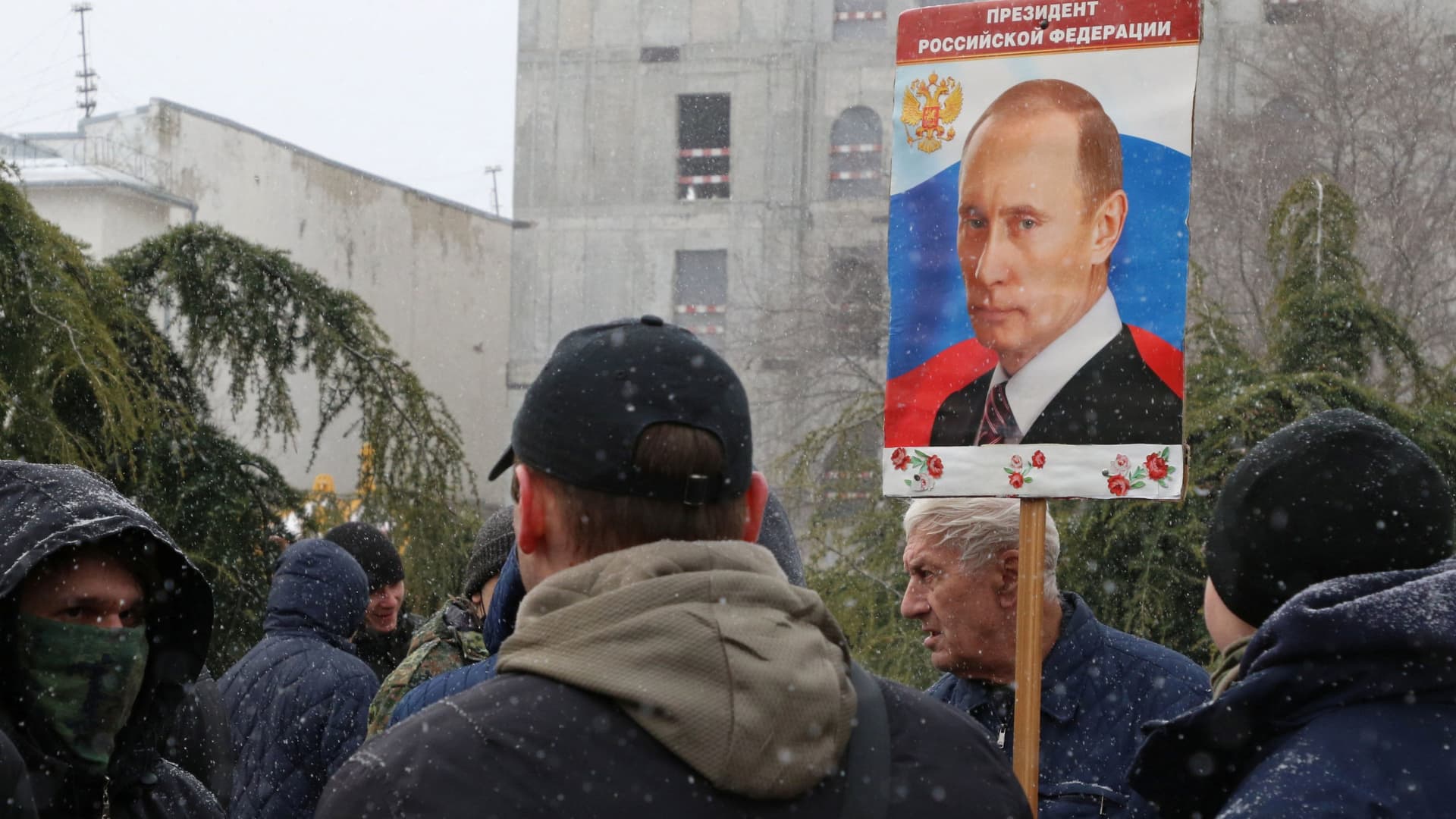 A man holds a portrait of Russian President Vladimir Putin during celebrations of the eighth anniversary of Russia's annexation of Crimea in Simferopol, Crimea March 18, 2022.