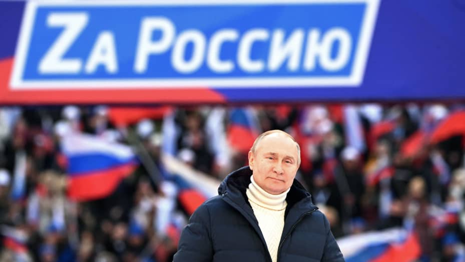 Russian President Vladimir Putin attends a concert marking the eighth anniversary of Russia's annexation of Crimea at the Luzhniki stadium in Moscow on March 18, 2022. The banner reads "For Russia".