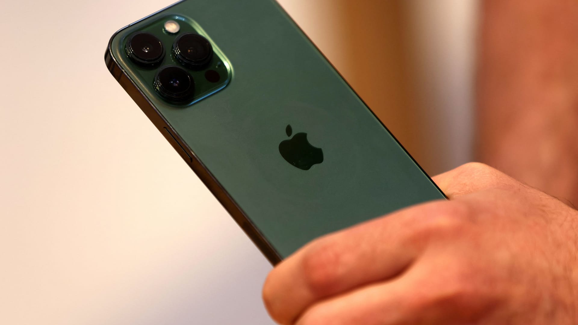 A customers holds the new green colour Apple iPhone 13 pro shortly after it went on sale inside the Apple Store on 5th Avenue in New York, March 18, 2022.