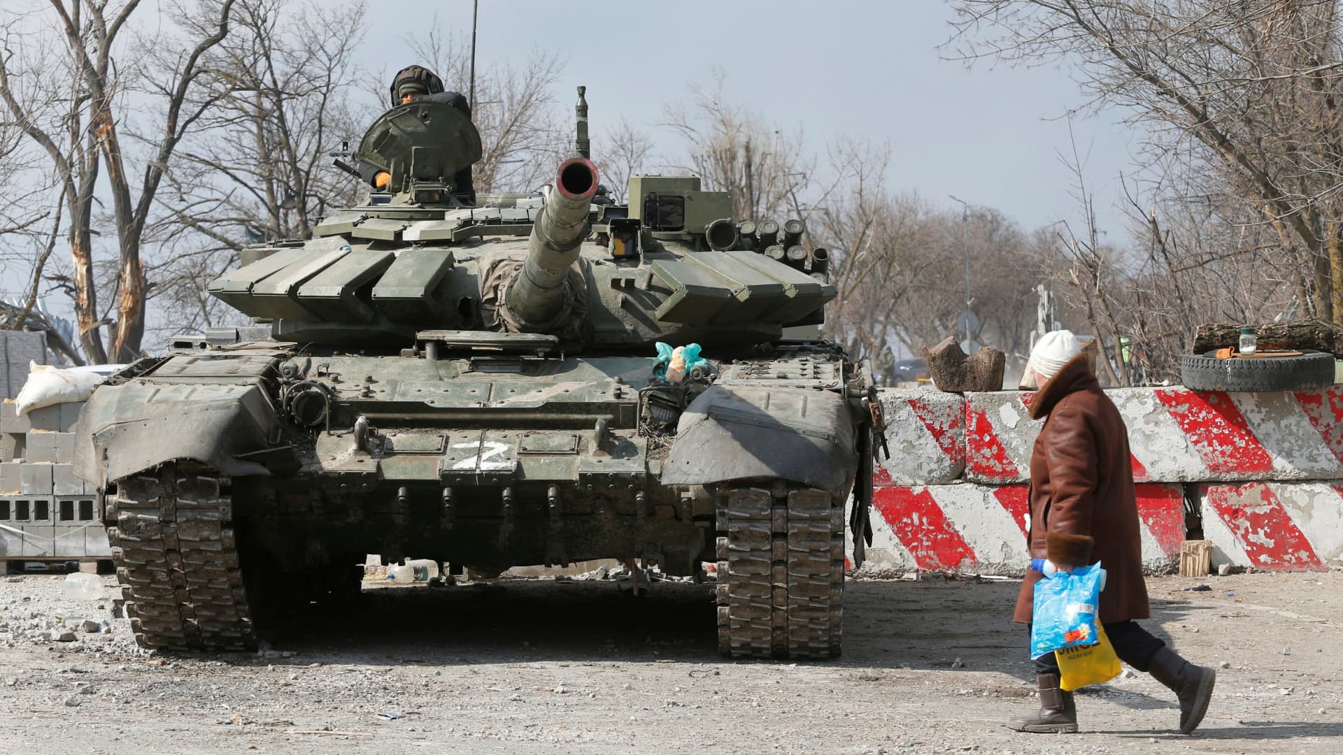 A local resident walks past a tank of pro-Russian troops during Ukraine-Russia conflict in the besieged southern port city of Mariupol, Ukraine March 18, 2022.