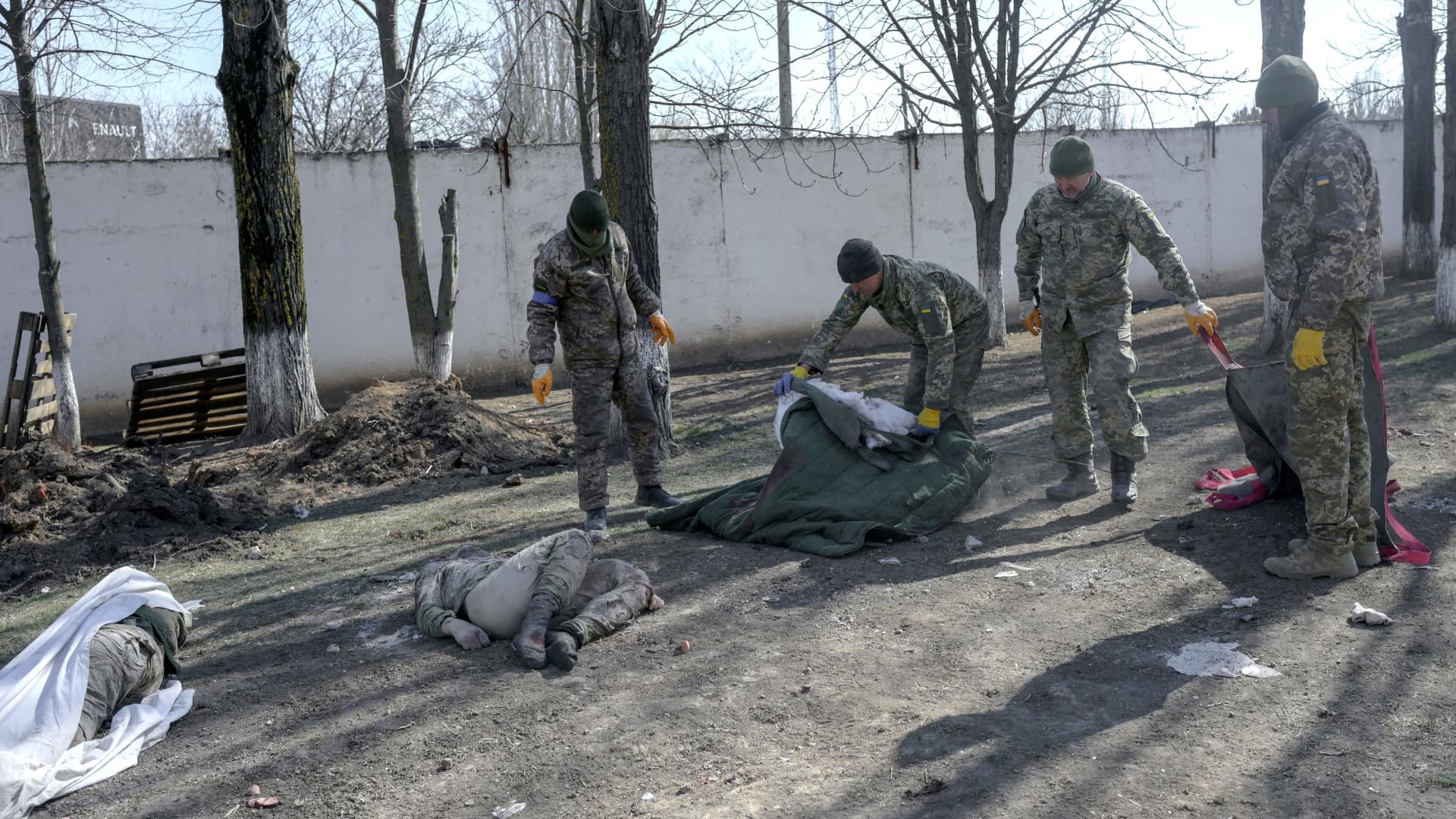 EDITORS NOTE: Graphic content / Ukrainian soldiers cover bodies of dead soldiers laying next to the military school hit by Russian rockets the day before, in Mykolaiv, southern Ukraine, on March 19, 2022.