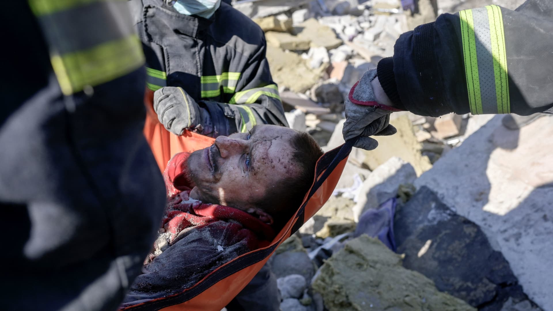 Rescuers carry a Ukrainian soldier saved after 30 hours from debris of the military school hit by Russian rockets, in Mykolaiv, southern Ukraine, on March 19, 2022.