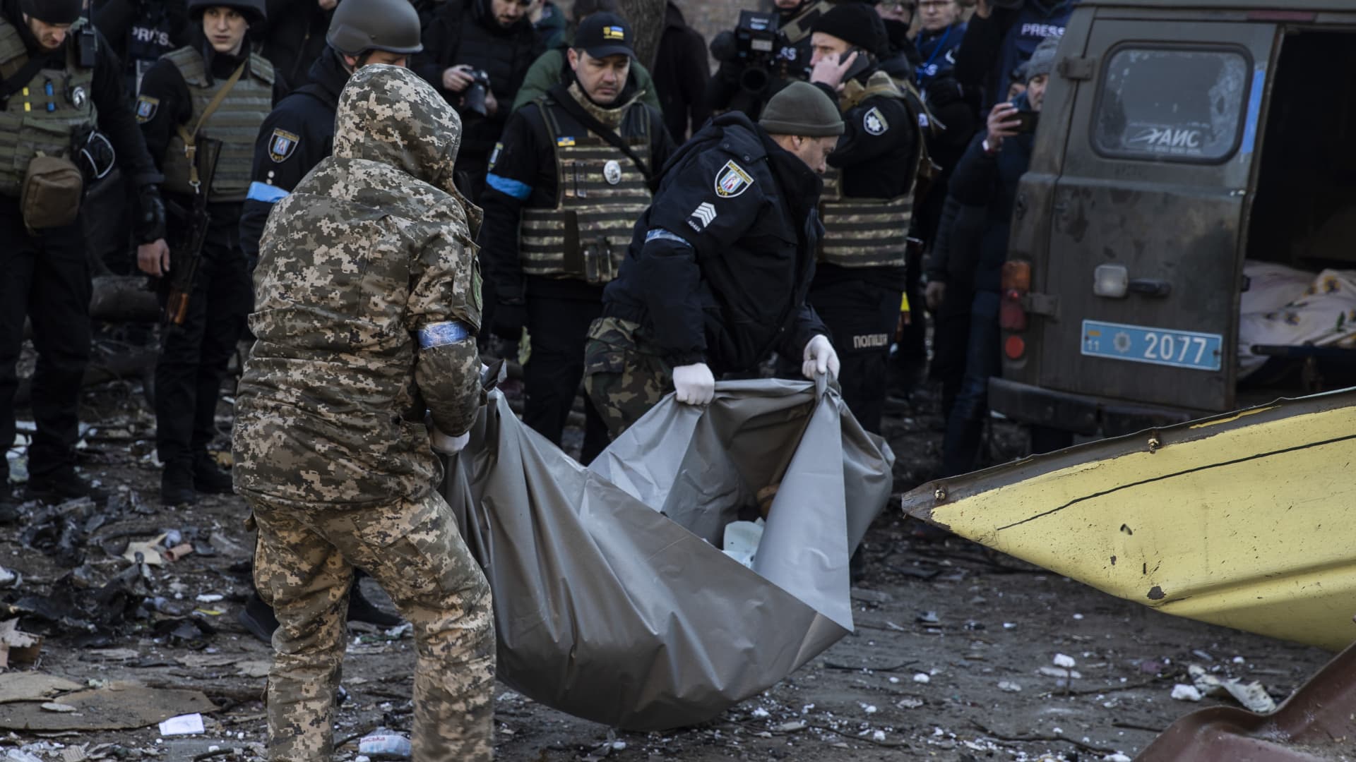 People carry a dead body after a residential buildings hit by a Russian attack in Kyiv, Ukraine on March 18, 2022.