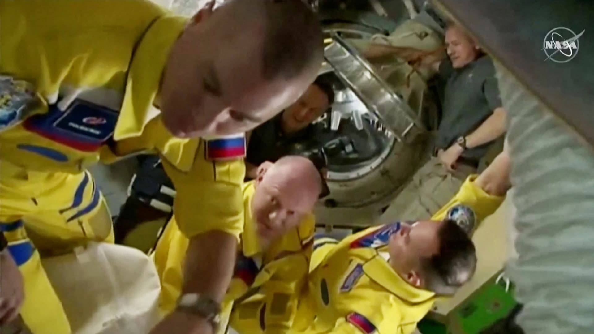 Russian cosmonauts Oleg Artemyev, Denis Matveev and Sergey Korsakov arrive wearing yellow and blue flight suits at the International Space Station after docking their Soyuz capsule March 18, 2022 i a still image from video. Video taken March 18, 2022.