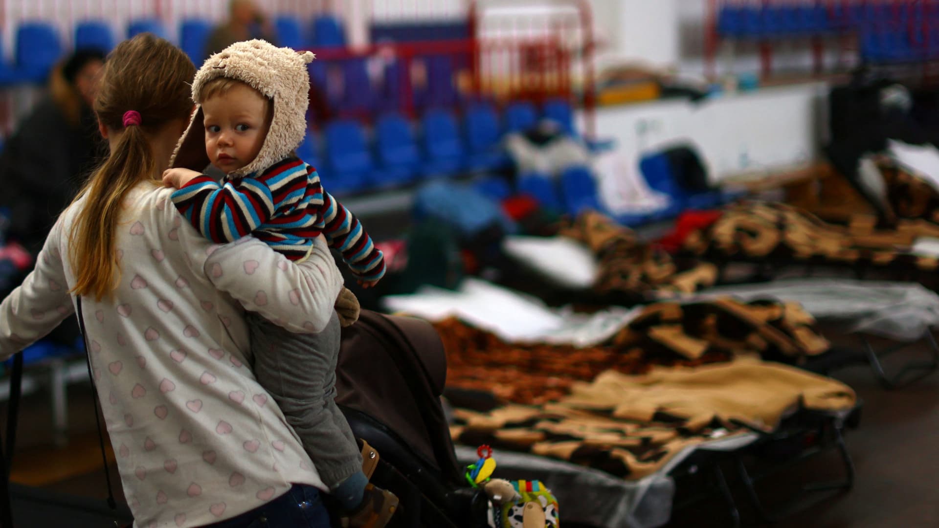 A mother with her child arrives at a sports hall of a primary school, transformed into temporary accommodation for people fleeing the Russian invasion of Ukraine, in Przemysl, Poland, March 19, 2022.