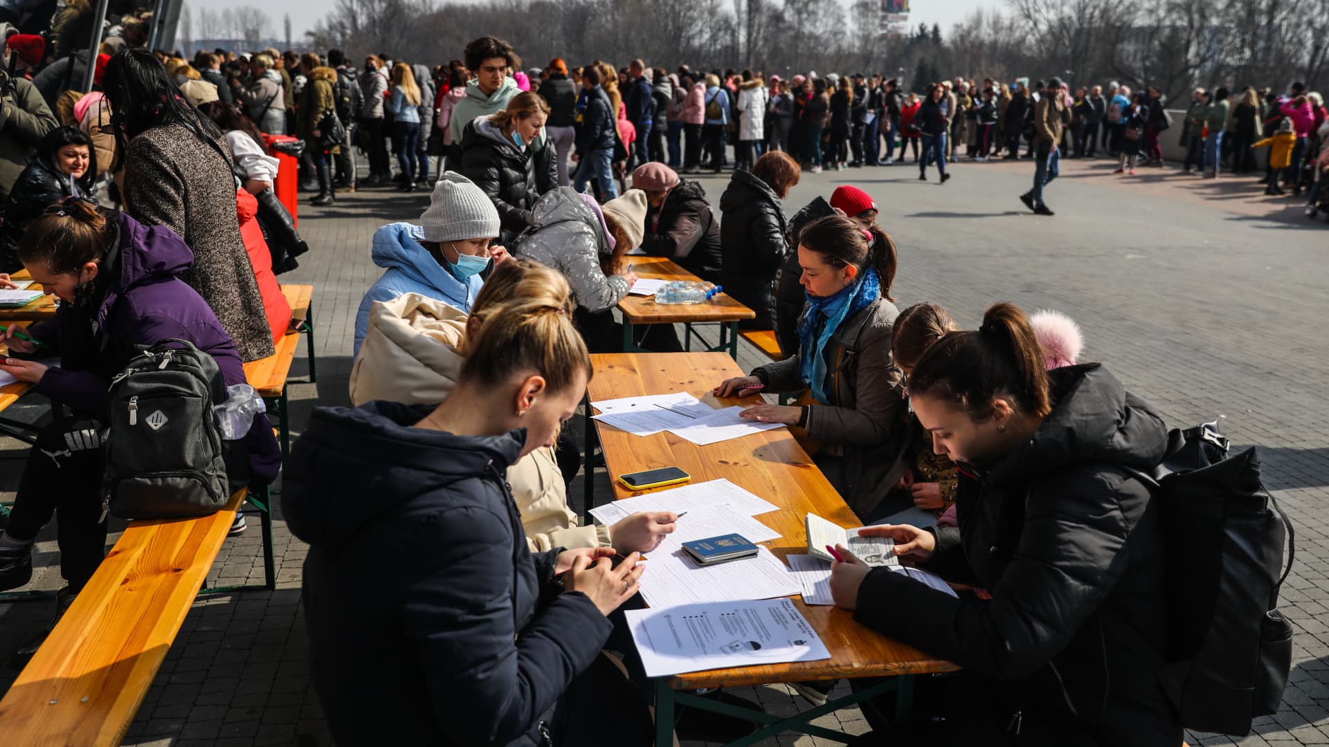 Refugees from Ukraine who fled to Poland after Russian attack are filling in documents in front of a register point at Tauron Arena where they can obtain a PESEL national identification number and remain in the country. Krakow, Poland on March 16, 2022.