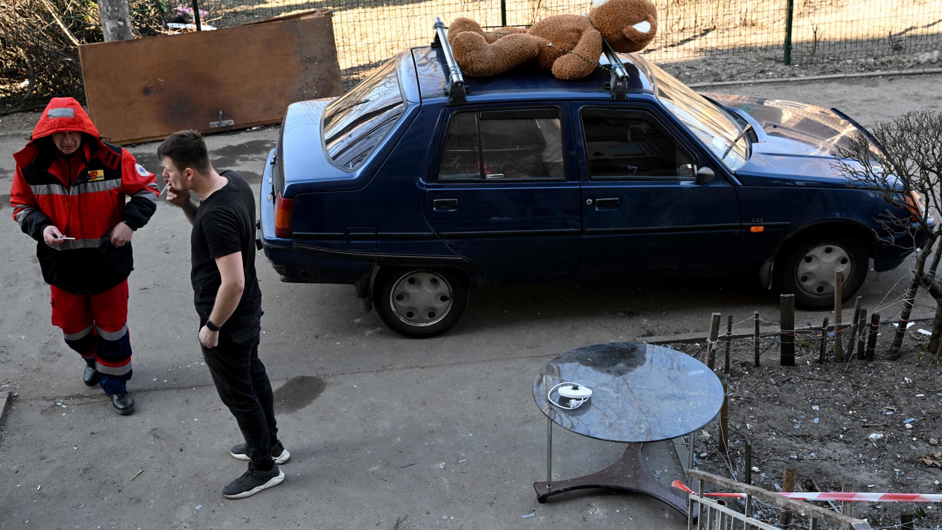 A local resident smokes a cigarette after retrieving amongst other things, a huge teddy bear, from his destroyed apartment, located in a five-storey residential building that partially collapsed after shelling the day before by Russian troops trying to encircle the Ukrainian capital as part of their slow-moving offensives, in Kyiv on March 20, 2022.