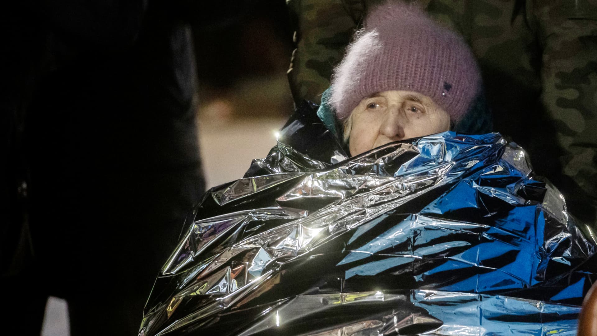 An old lady from Ukraine sits in a wheelchair, wrapped in a heat foil rescue foil against the frosty temperatures at the Medyka border crossing in Poland.