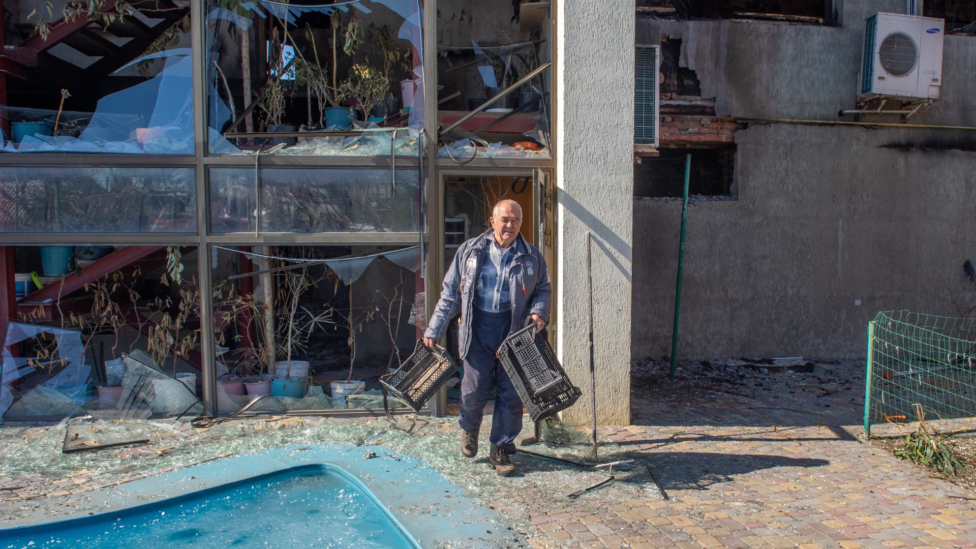 A man leaves with a few belongings from a building damaged after a Russian rocket fire in the cottage district of Kharkiv, Ukraine on March 20, 2022.