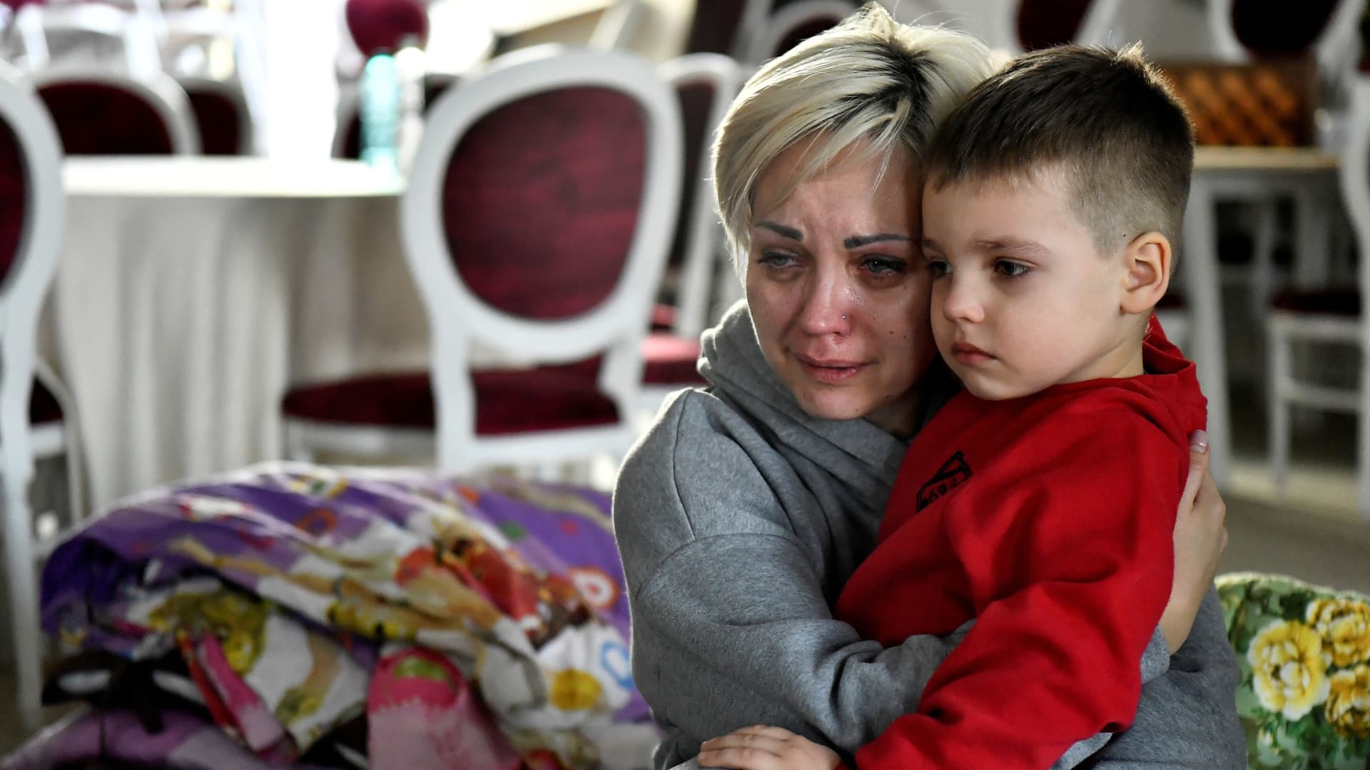 Egor, 5, comforts his mother Helen Yakubets who cries in a ballroom, which has been converted to a temporary shelter, at the Mandachi hotel after fleeing from Chernihiv in Ukraine to Romania, following Russia's invasion of Ukraine, at the border crossing in Suceava, Romania, March 20, 2022. Her 18 year old son and husband remain in Ukraine to fight.