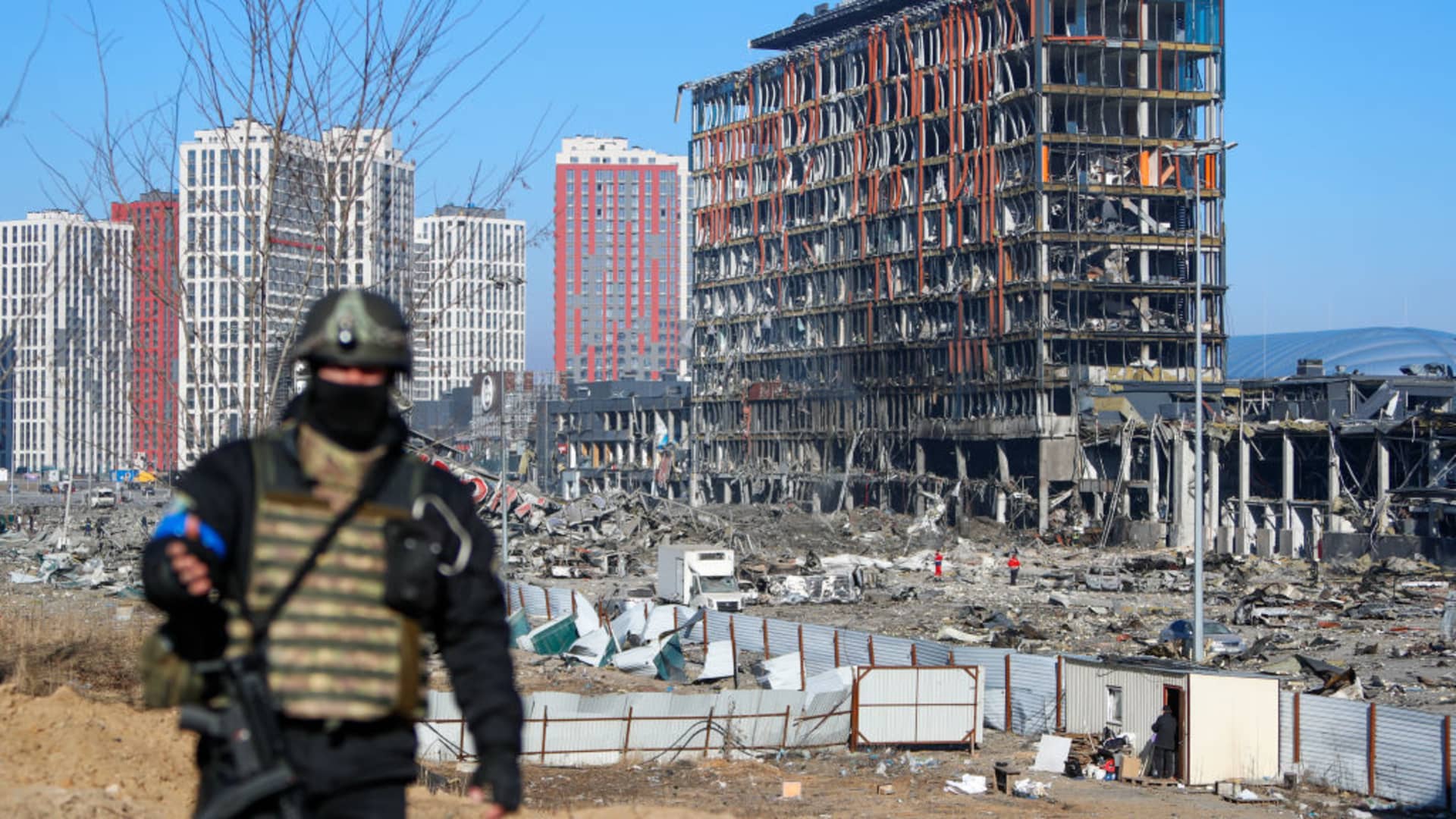 A police officer stands guard near the wreckage and debris outside a damaged shopping centre in the Podilskyi district of Kyiv by Russian air strikes, amid Russian invasion, in Kyiv, Ukraine, 21 March 2022.