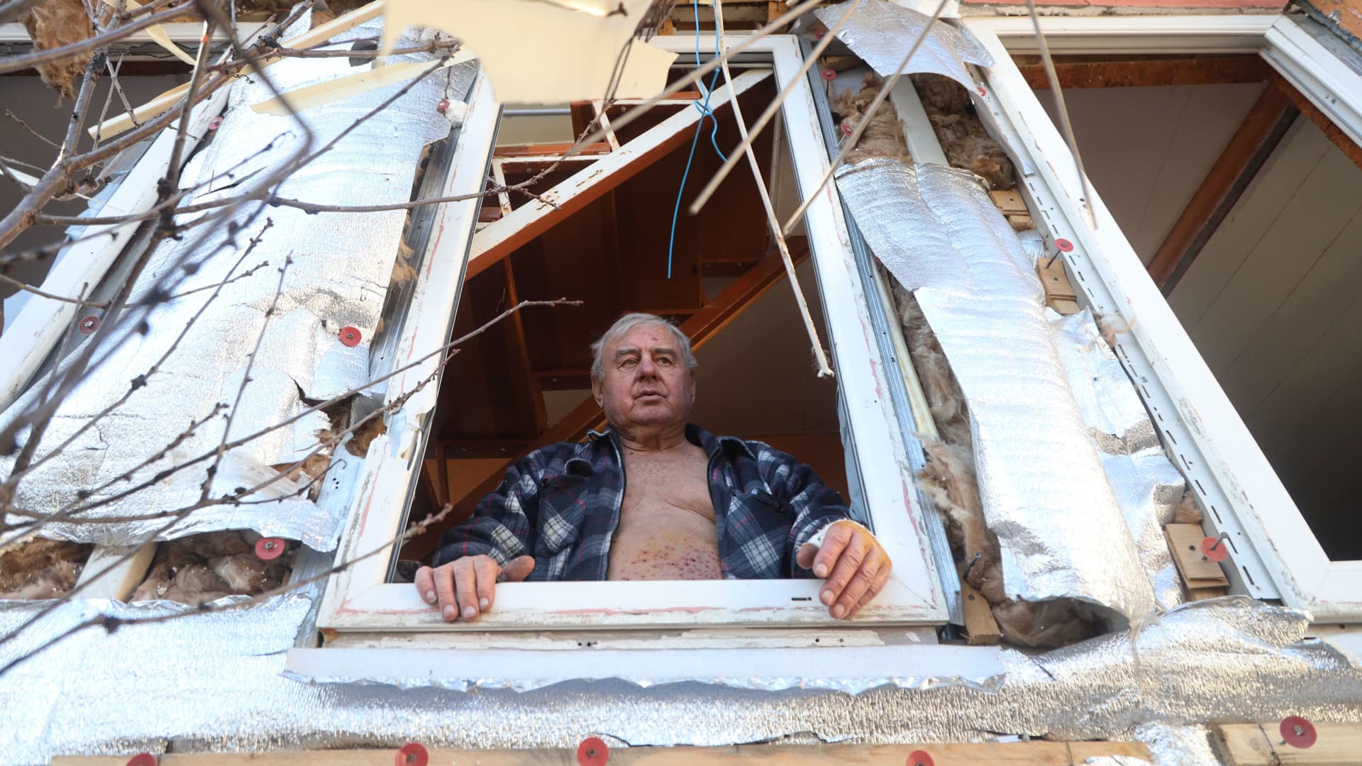 A man looks out of the window of his partially destroyed house after the shelling by Russian warships, on the outskirts of Odessa, on March 21, 2022.