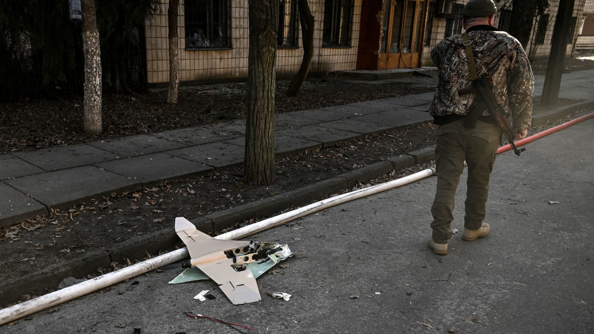 A Ukranian serviceman stands next to a downed Russian drone in the area of a research institute, part of Ukraine's National Academy of Science, after a strike, in northwestern Kyiv, on March 22, 2022.