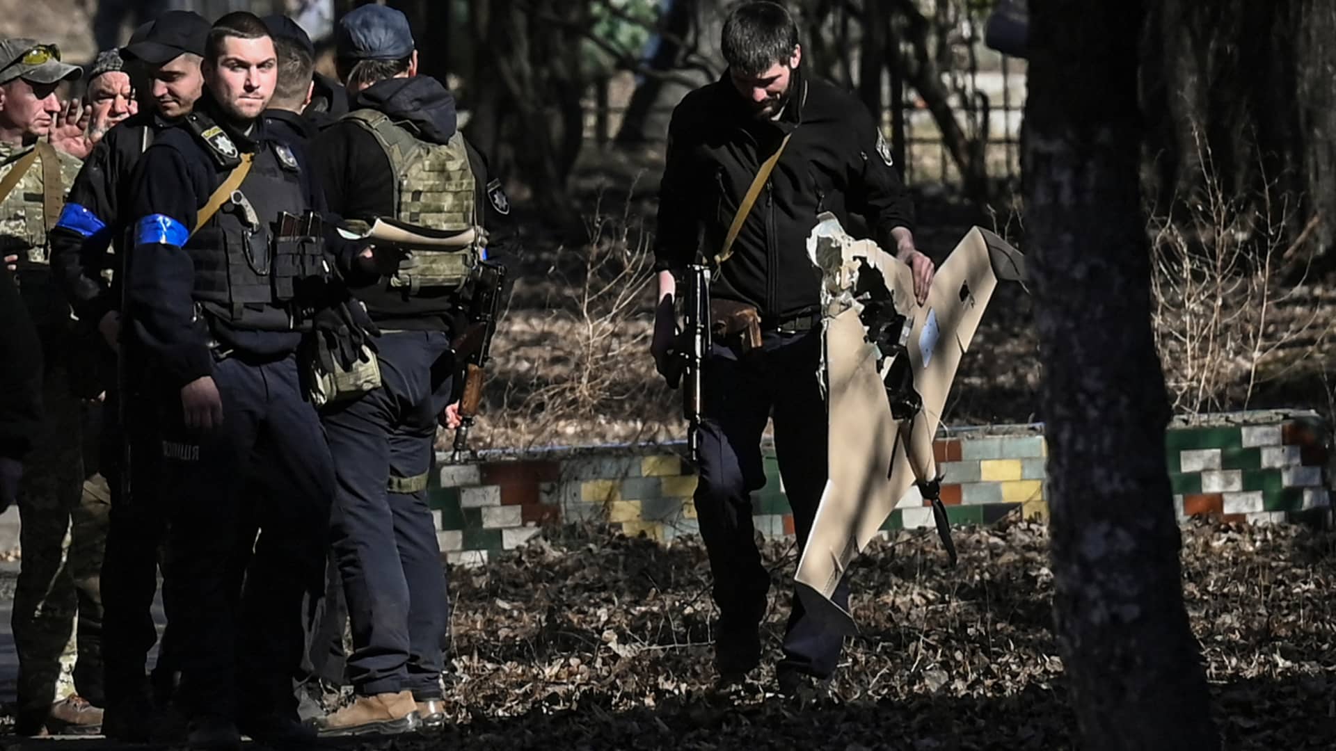 An Ukranian serviceman carries a downed Russian drone in the area of a research institute, part of Ukraine's National Academy of Science, after a strike, in northwestern Kyiv, on March 22, 2022.