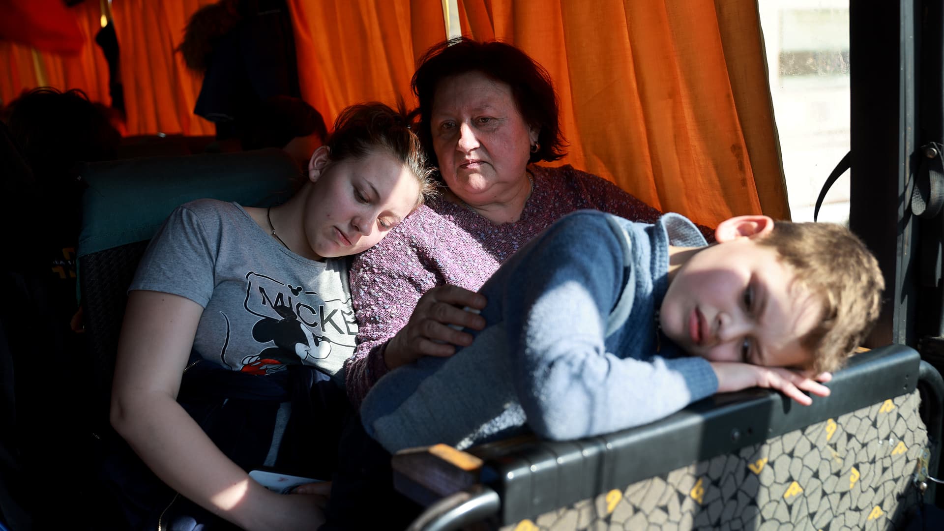 Sywasz Elizabeth, Samarska Ludmyla and Pylypenko Arsenij wait on a bus after arriving safely on a train from the besieged city of Mariupol that is under Russian military attack on March 22, 2022 in Lviv, Ukraine.
