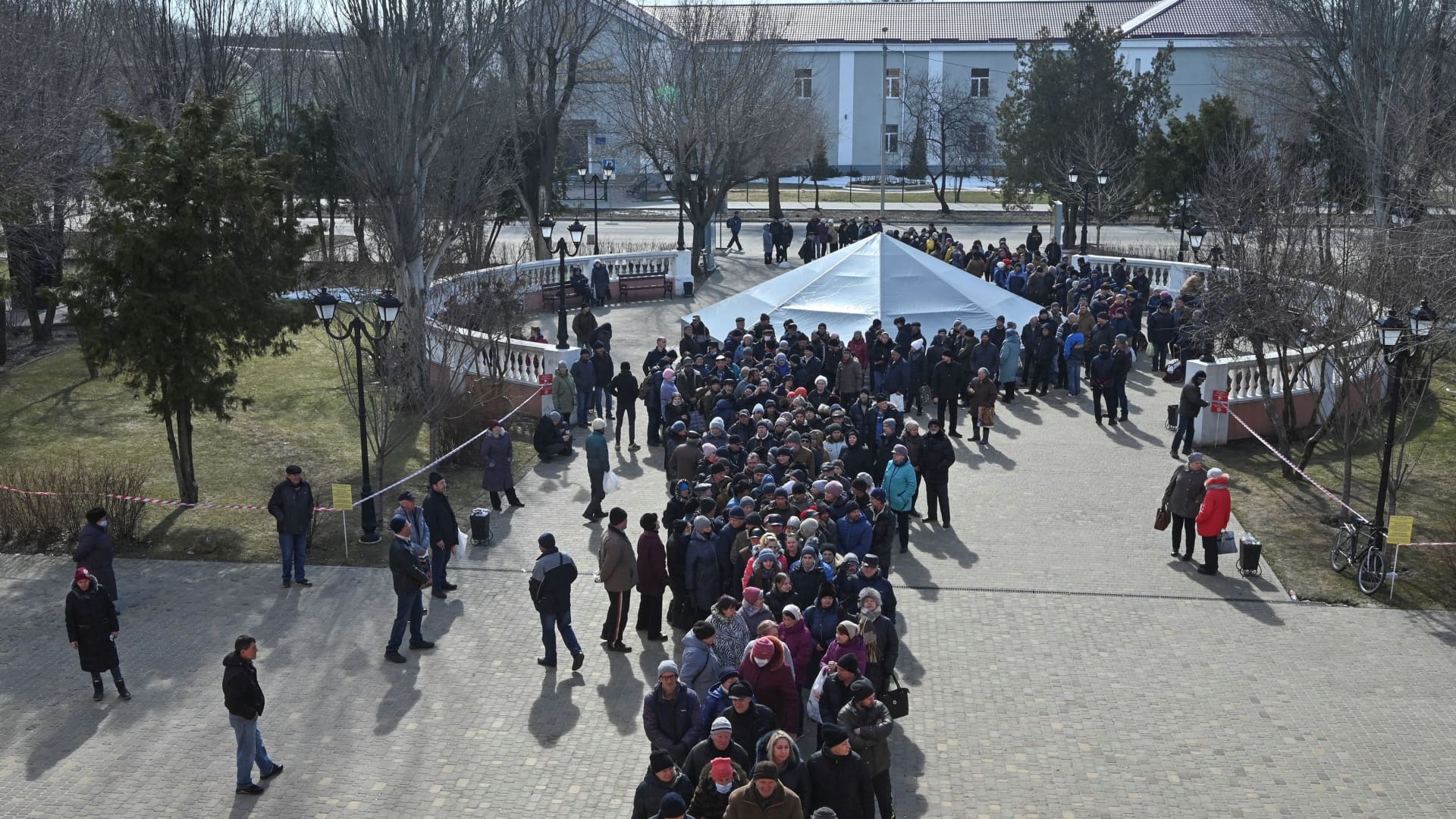 People wait in queue to take free food as part of humanitarian aid, amid Russia's invasion of Ukraine, outside the Drama Theatre, in Sievierodonetsk, Luhansk region, Ukraine March 23, 2022.