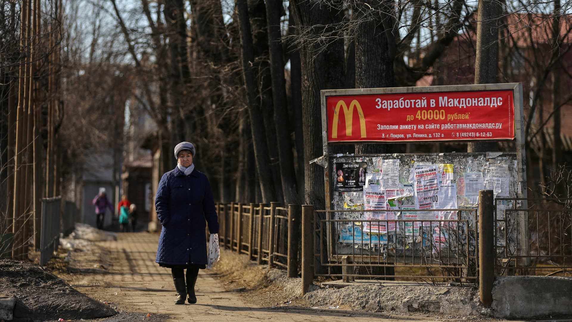 A woman walks along a street past a banner offering job at McDonald's in the town of Pokrov in Vladimir Region, Russia March 21, 2022.