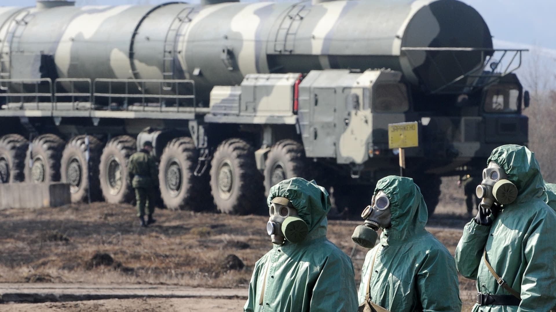 Russian soldiers wear chemical protection suits as they stand next to a military fueler on the base of a prime mover of Russian Topol intercontinental ballistic missile during a training session at the Serpukhov's military missile forces research institute some 100km outside Moscow on April 6, 2010. T