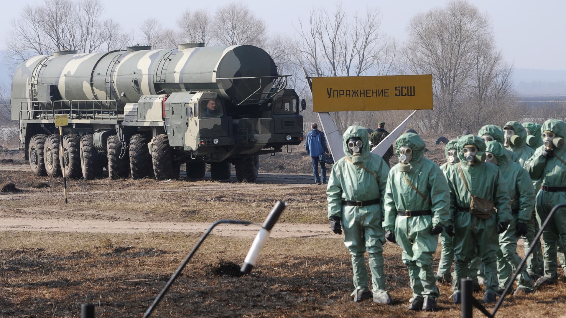 Russian soldiers wear chemical protection suits as they stand next to a military fueler on the base of a prime mover of Russian Topol intercontinental ballistic missile during a training session at the Serpukhov's military missile forces research institute some 100km outside Moscow on April 6, 2010.