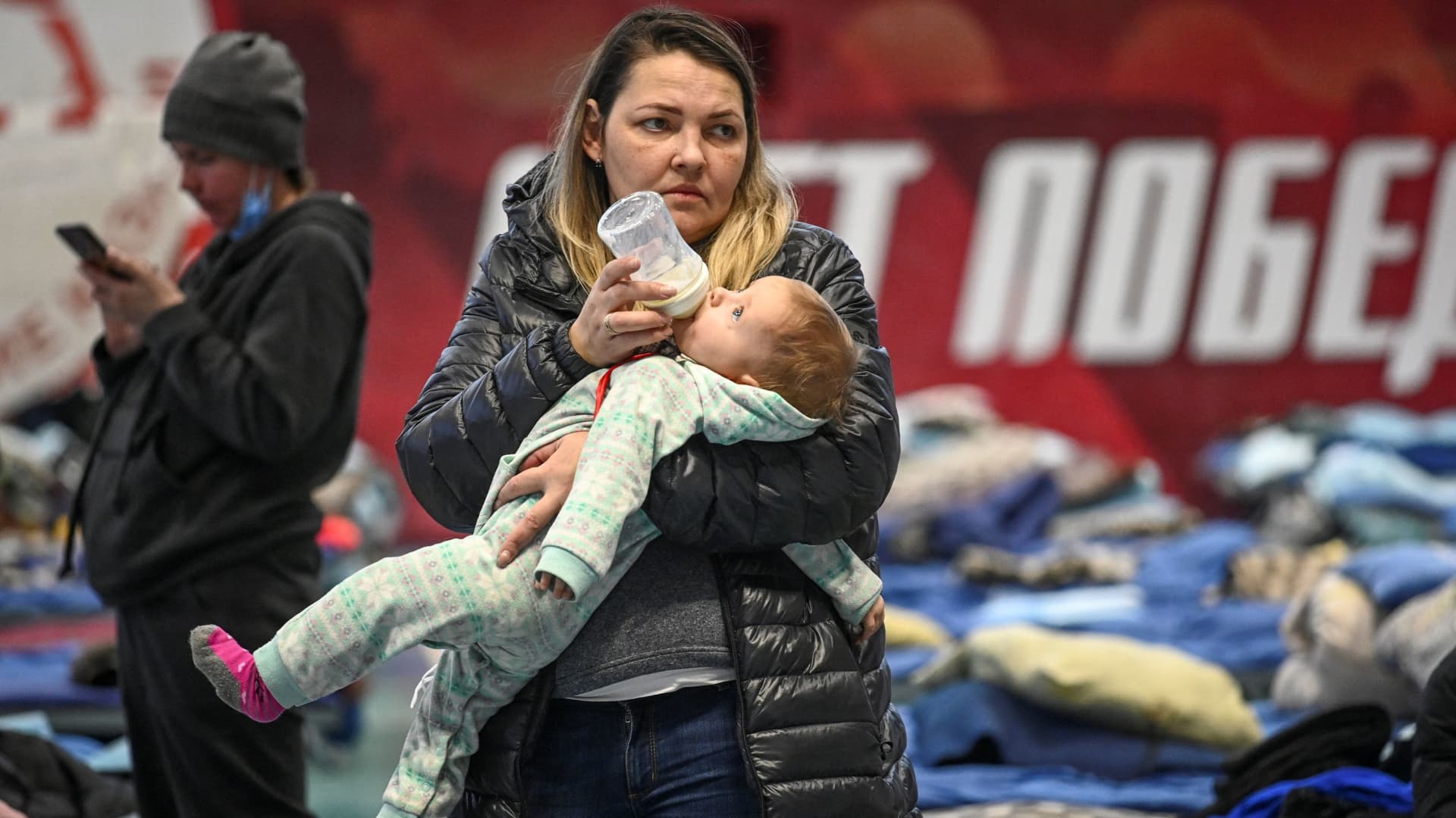A woman evacuated from the Ukrainian city of Mariupol feeds a child at a temporary accommodation centre for evacuees located in the building of a local sports school in Taganrog in the Rostov region, Russia March 23, 2022.