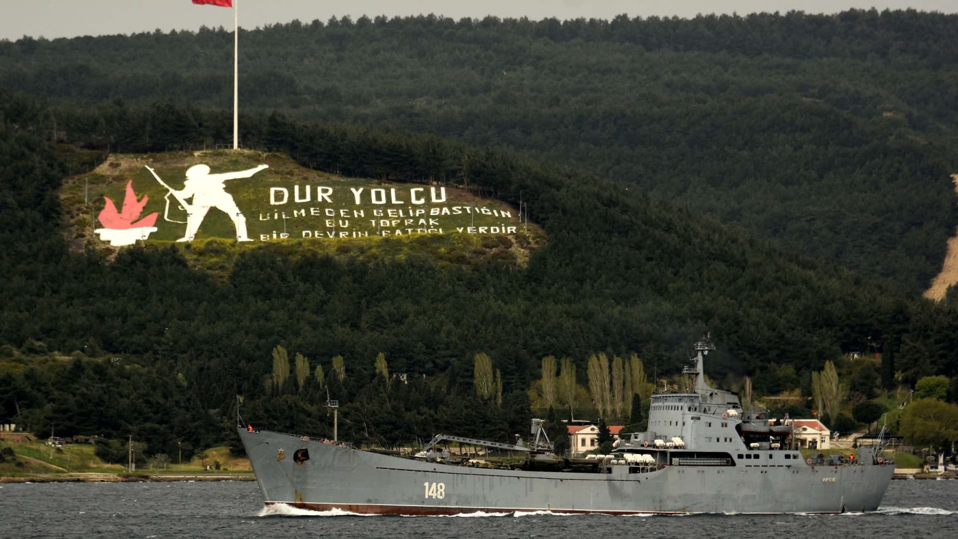 In this image from 2018, the Russian warship Orsk passes through Turkey's Dardanelles Strait. Military vehicles and a large hoist are visible on deck.