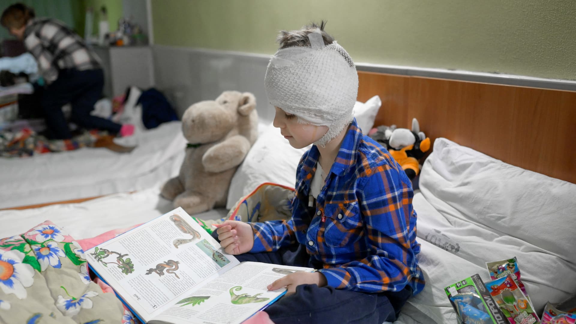 Misha, 5, who lost his mother some weeks ago and got injured during a Russian strike, reads a book during his time in a basement at a hospital on March 26, 2022, in Mykolaiv.