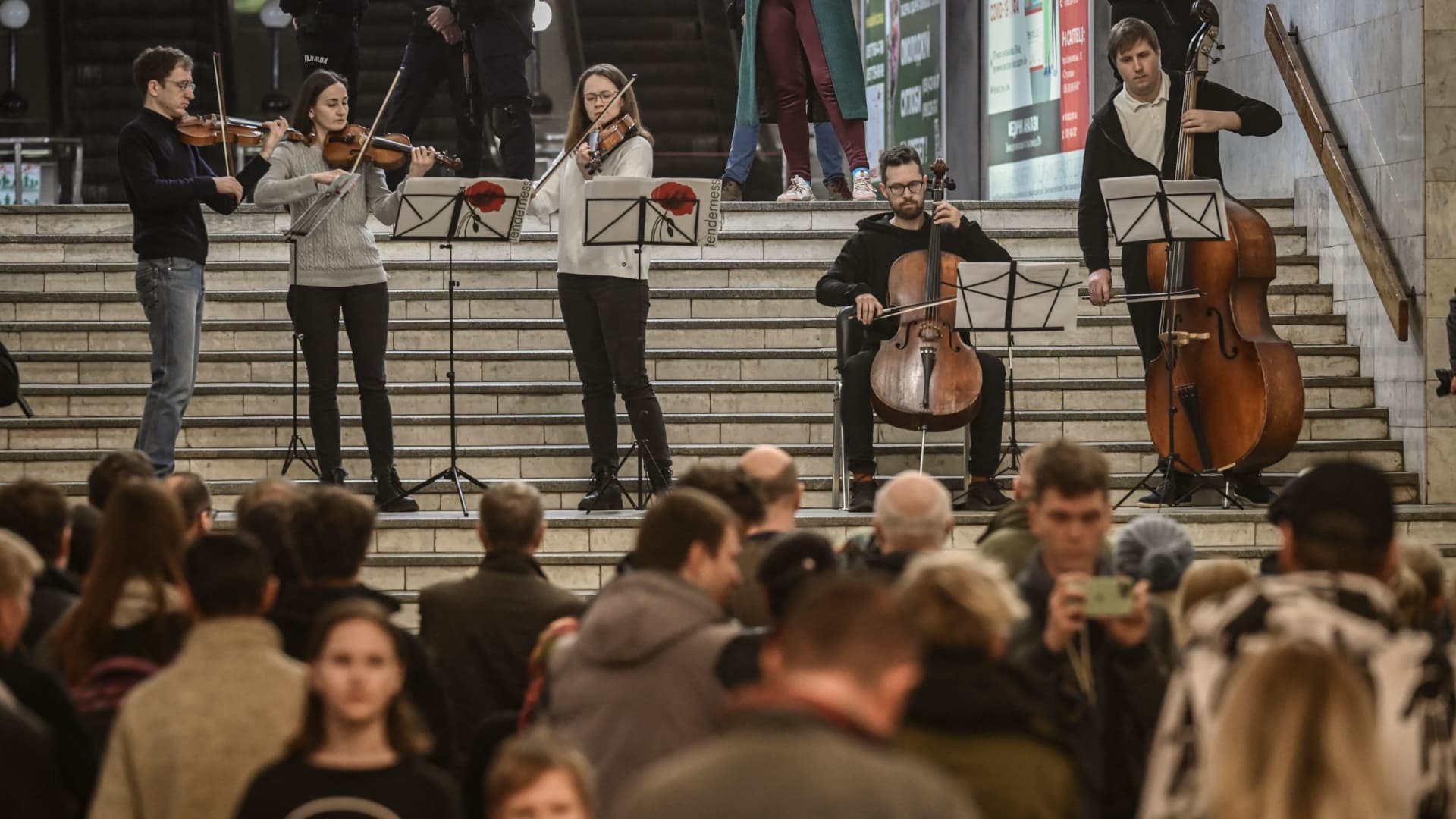 Musicians play for people living in a metro station used as a bomb shelter in Kharkiv on March 26, 2022, during Russia's military invasion launched on Ukraine.