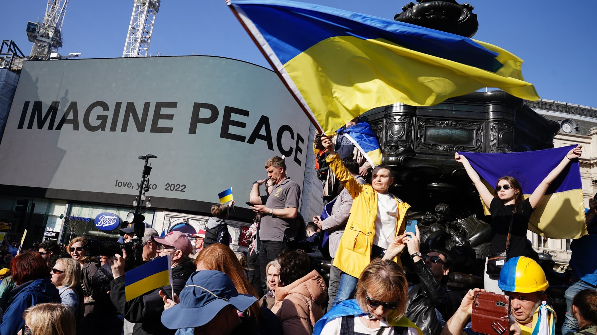 People pass the Yoko Ono Imagine Peace sign at Piccadilly, during a solidarity march in London for Ukraine, following the Russian invasion. Picture date: Saturday March 26, 2022. 