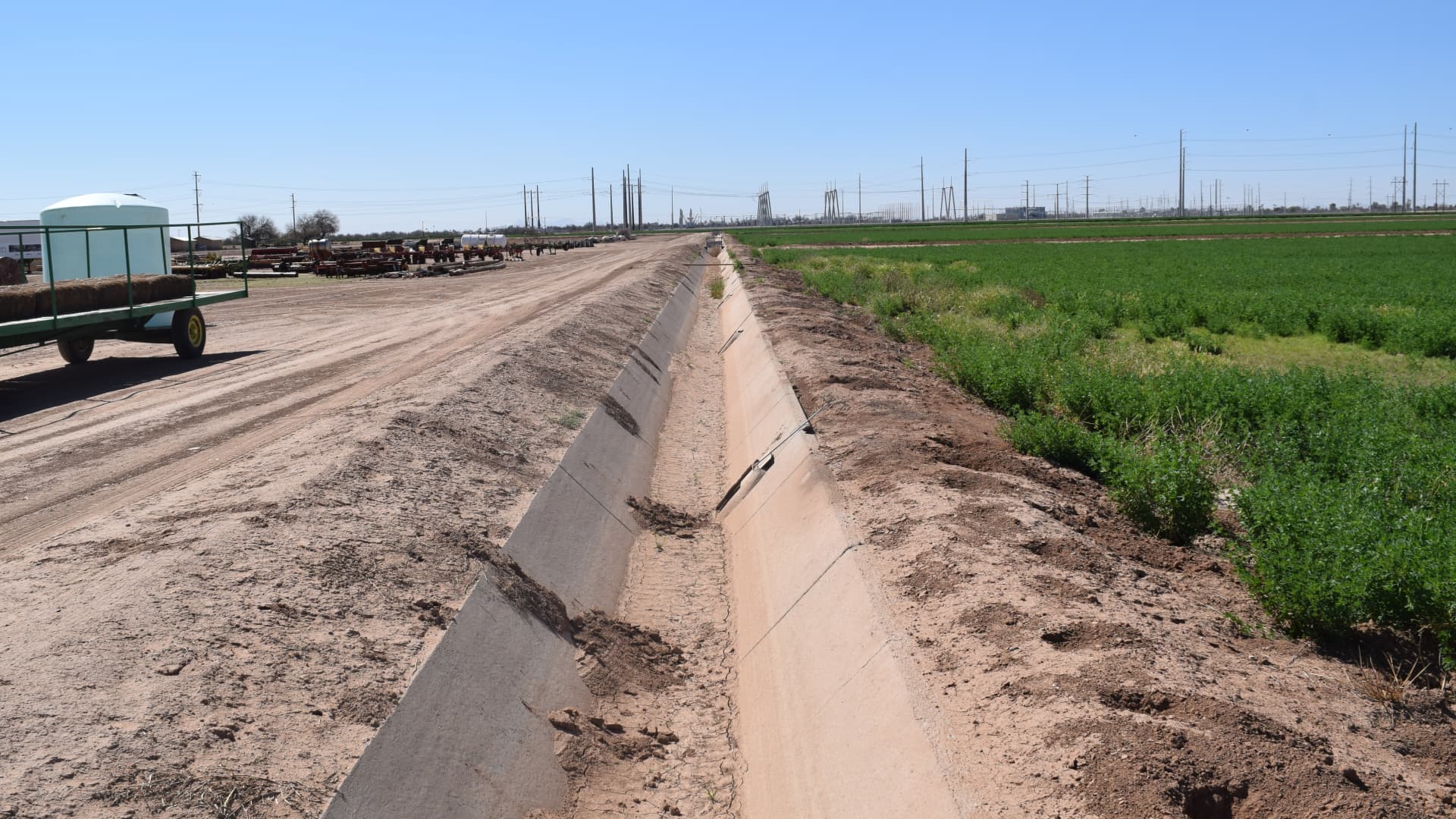 An empty irrigation canal runs along an alfalfa field owned by Caywood Farms, a cotton farm near Casa Grande, Arizona.