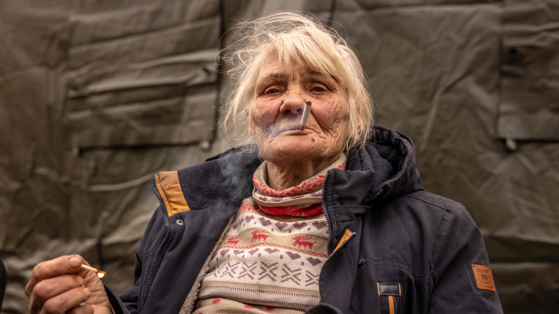 A woman smokes a cigarette after fleeing her home in the suburbs of Kyiv, on March 26, 2022, during Russia's military invasion launched on Ukraine.