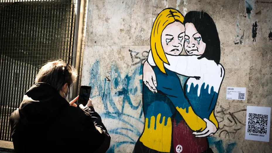 Anti-Ukraine war mural by Italian street artist known by the name of 'Laika' depicting a hug between two women, one dressed in the Russian, the other in the Ukrainian national colors, respectively, above the word MIR (Peace) In the Ostiense district on March 09, 2022 in Rome, Italy. (Photo by Andrea Ronchini/NurPhoto via Getty Images)