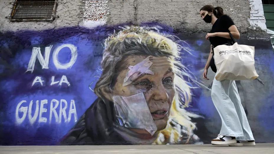 A woman walks pass the mural "No to war" by muralist Maximiliano Bagnasco in Buenos Aires on March 5, 2022.