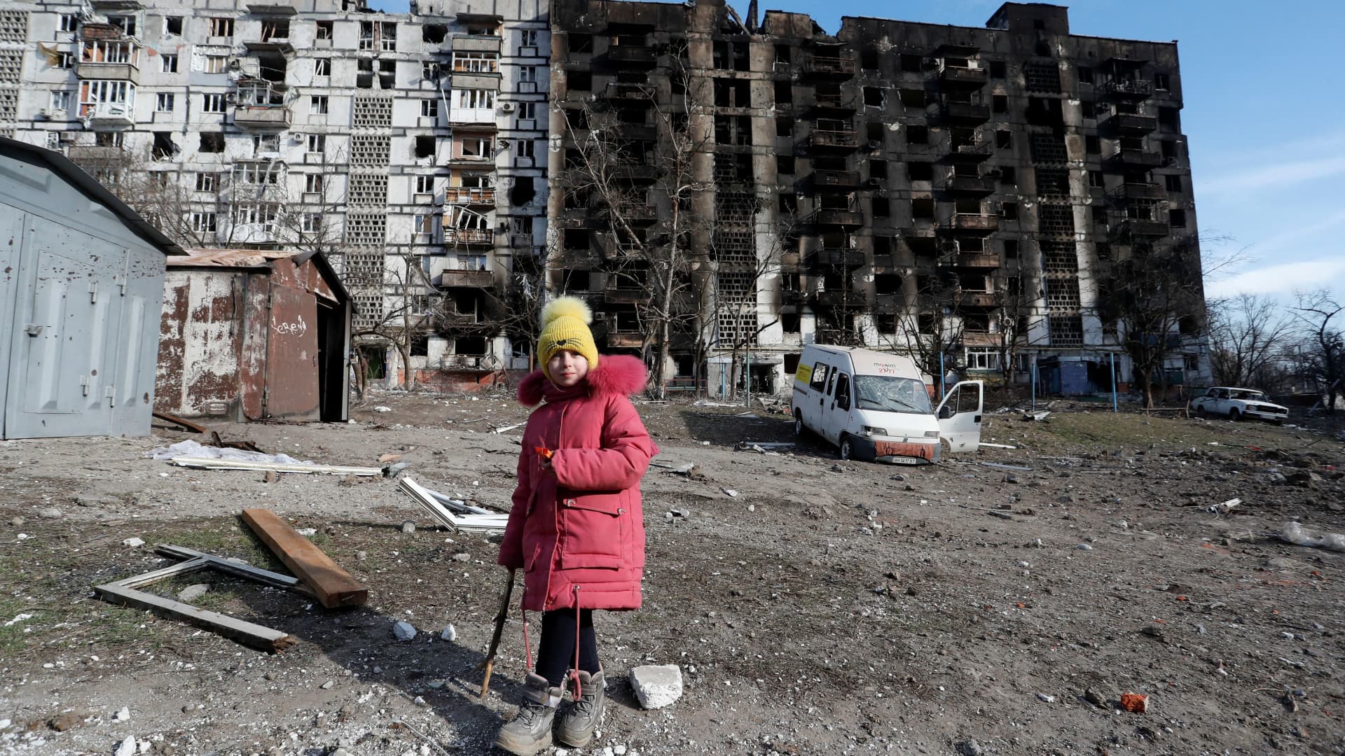 A girl walks in the courtyard of an apartment building destroyed in the course of Ukraine-Russia conflict in the besieged southern port city of Mariupol, Ukraine March 28, 2022.