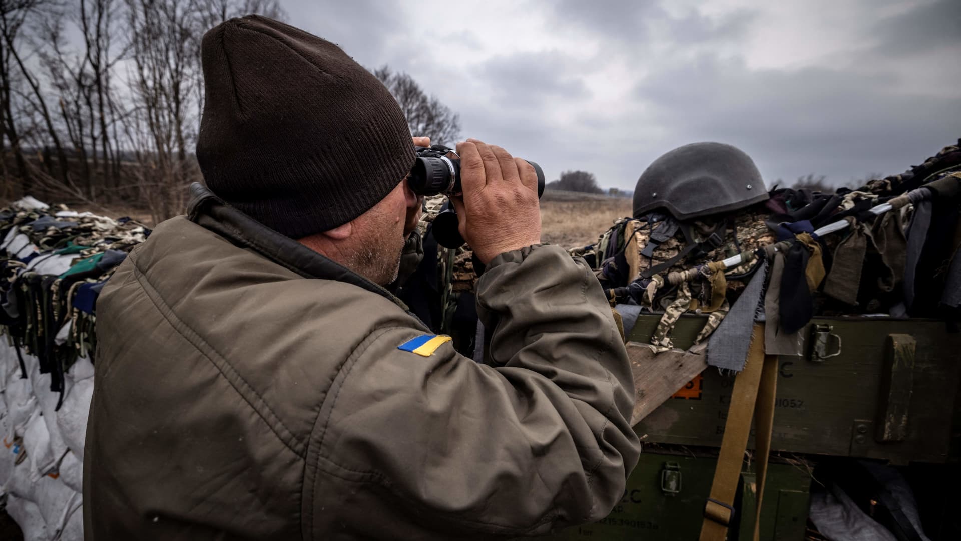 A Ukrainian serviceman looks through binoculars at the front line, east of Kharkiv, on March 31, 2022, during Russia's military invasion on Ukraine. 