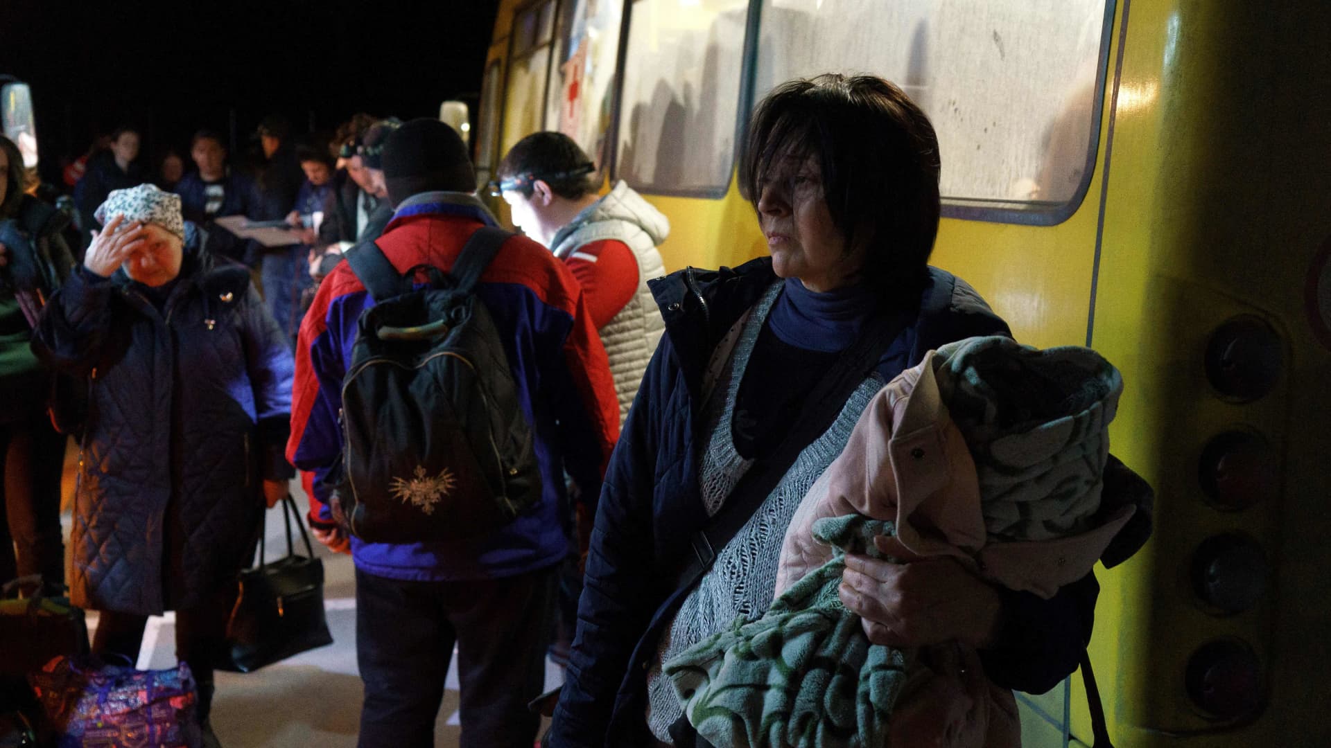 Passengers disembark as a convoy of 30 buses carrying evacuees from Mariupol and Melitopol arrive at the registration center in Zaporizhzhia, on April 1, 2022.