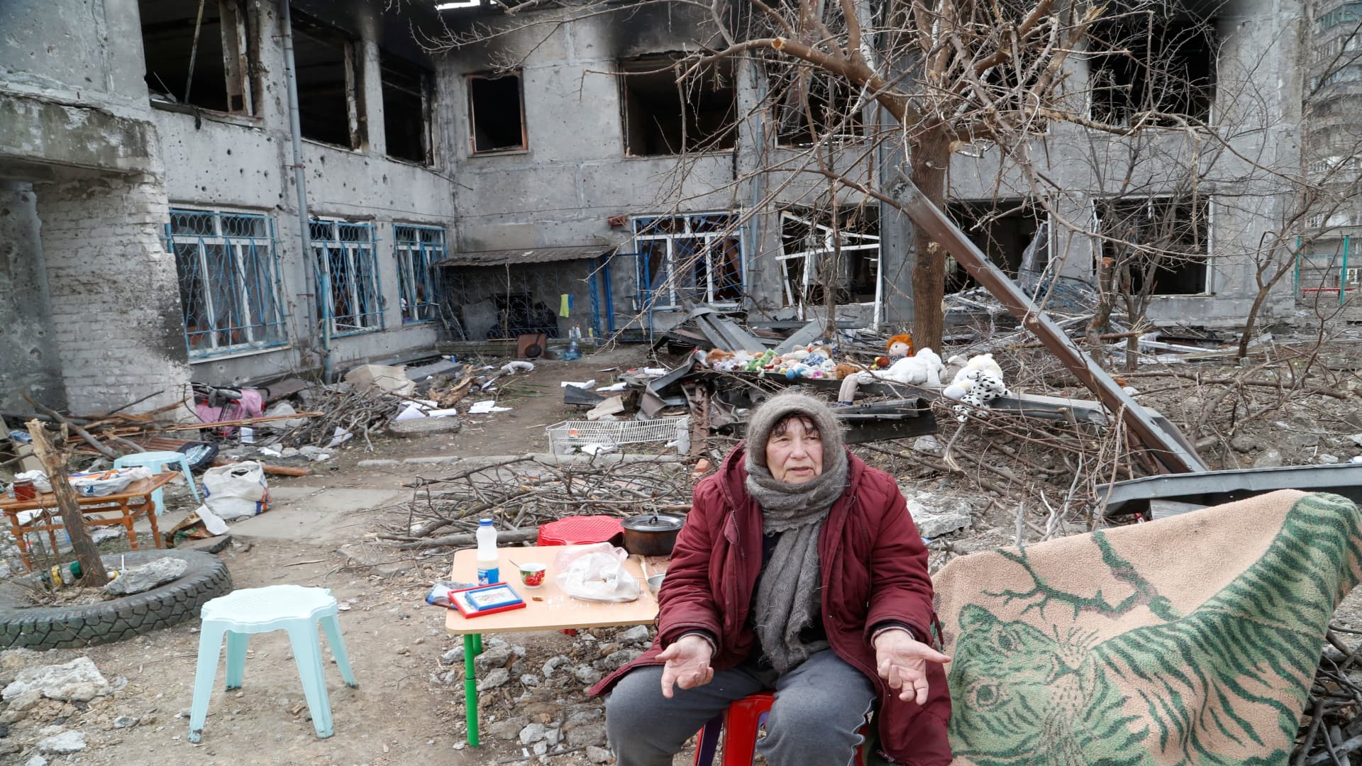 Local resident and pensioner Valentina Popyi, 75, who seeks refuge in a children's home damaged in the course of Ukraine-Russia conflict, speaks with neighbours in the southern port city of Mariupol, Ukraine April 1, 2022. 