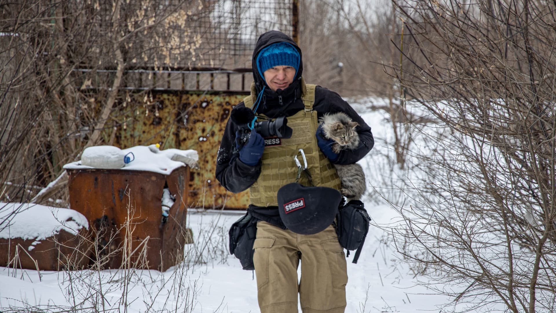 Ukrainian photographer Maksim Levin carries a cat near the line of separation from Russian-backed separatists in Donetsk region, Ukraine January 25, 2022. Picture taken January 25, 2022.