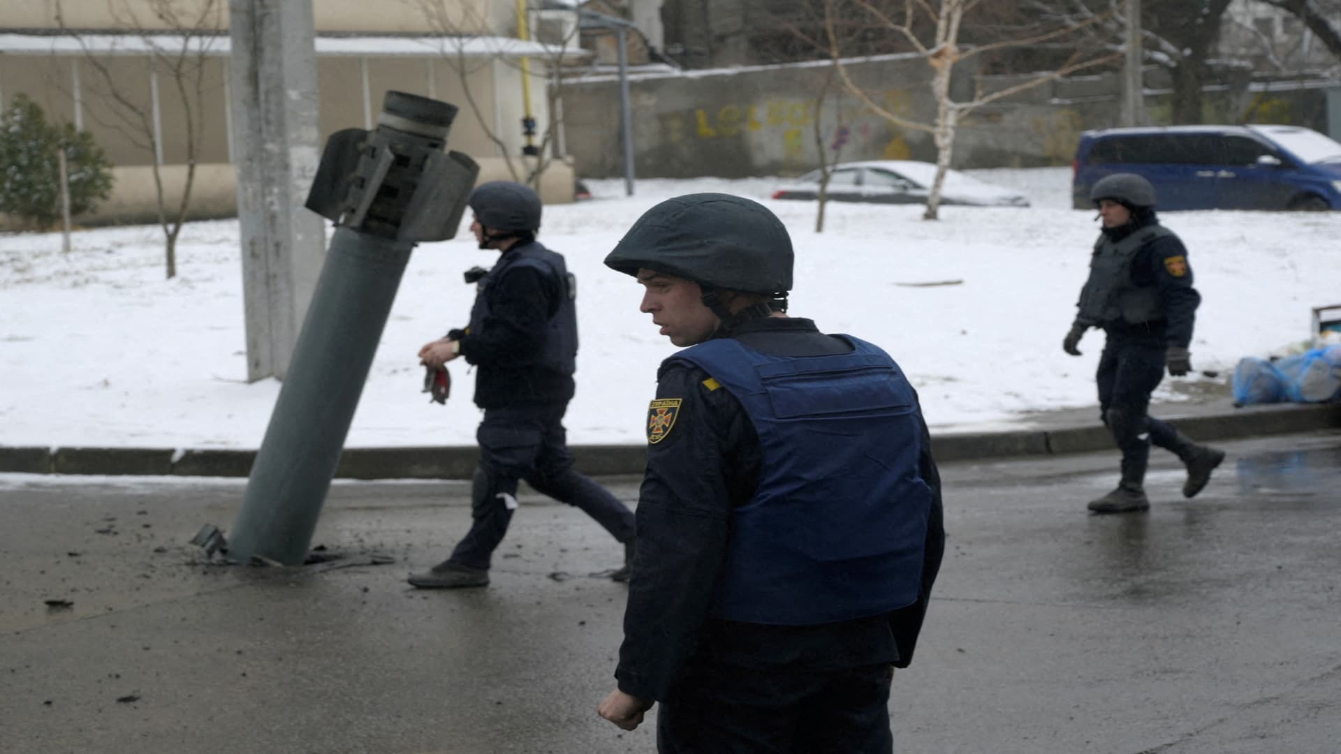 FILE PHOTO: Members of the State Emergency Service of Ukraine walk towards a rocket case stuck on the driveway following recent shelling in Kharkiv, Ukraine February 25, 2022. 