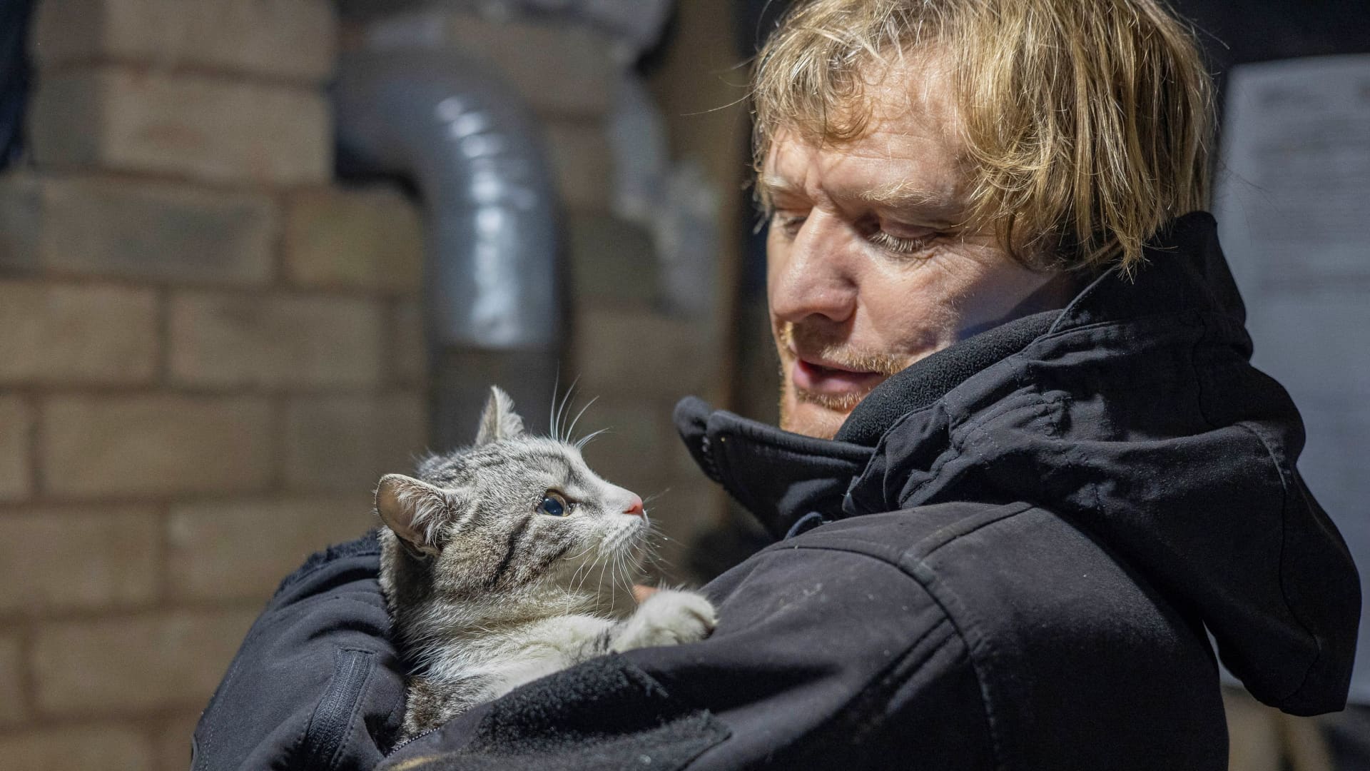 Ukrainian photographer Maksim Levin holds a cat near the line of separation from Russian-backed separatists in Luhansk region, Ukraine January 6, 2022. Picture taken January 6, 2022.