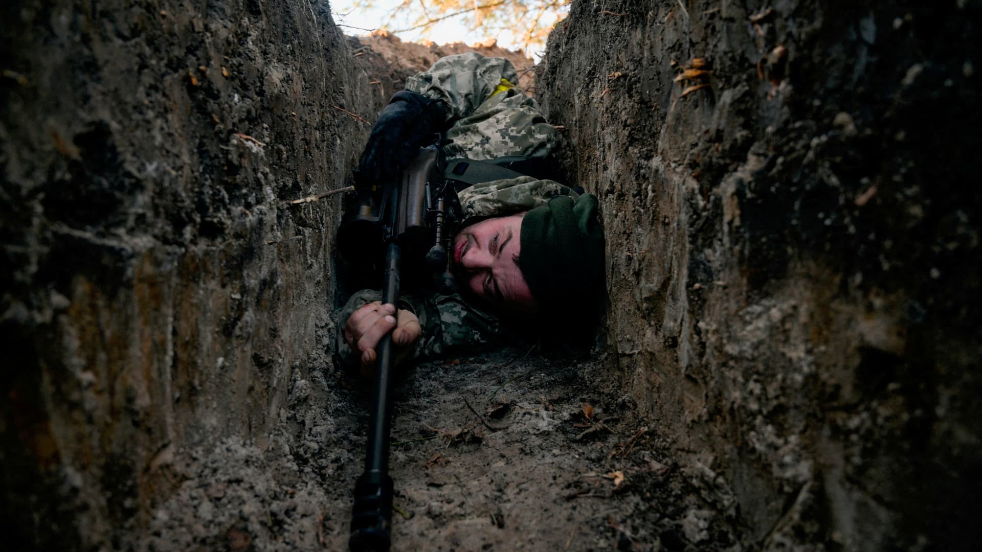 FILE PHOTO: A Ukrainian soldier hides from a helicopter airstrike amid Russia's invasion of Ukraine, near Demydiv, Ukraine March 10, 2022. 