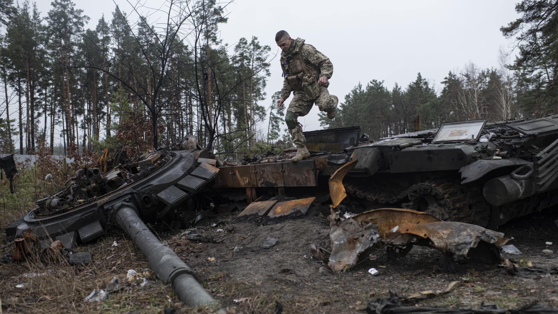 A Ukrainian soldier inspects a burnt Russian tank on April 2, 2022 in Dmytrivka, just outside Kyiv. Russian forces around the capital have been pushed back in places by Ukrainian counter-attacks.
