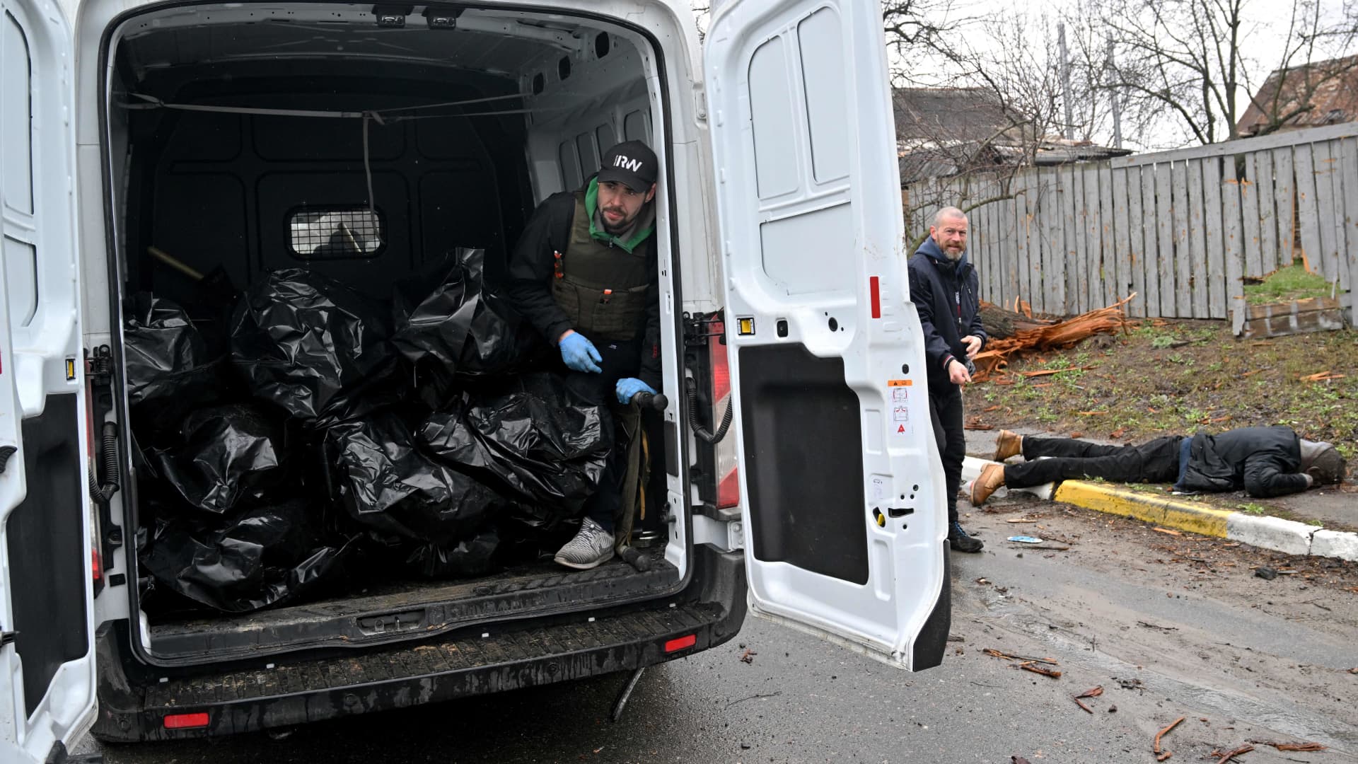 EDITORS NOTE: Graphic Content: A communal worker standing inside a van loaded with body bags, waits for another body to be wrapped and collected by a colleague following Russian shelling of the town of Bucha, not far from the Ukrainian capital of Kyiv on April 3, 2022.