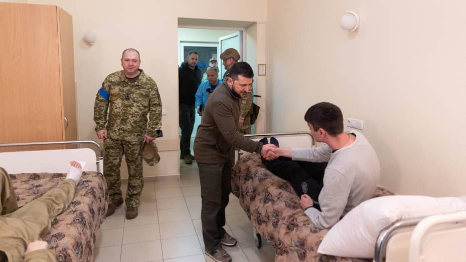 Ukraine's President Volodymyr Zelenskiy shakes a hand of an injured Ukrainian service member, as Russia's attack on Ukraine continues, during a visit of a military hospital in Kyiv, Ukraine April 3, 2022. Ukrainian Presidential Press Service/Handout via REUTERS ATTENTION EDITORS - THIS IMAGE HAS BEEN SUPPLIED BY A THIRD PARTY.