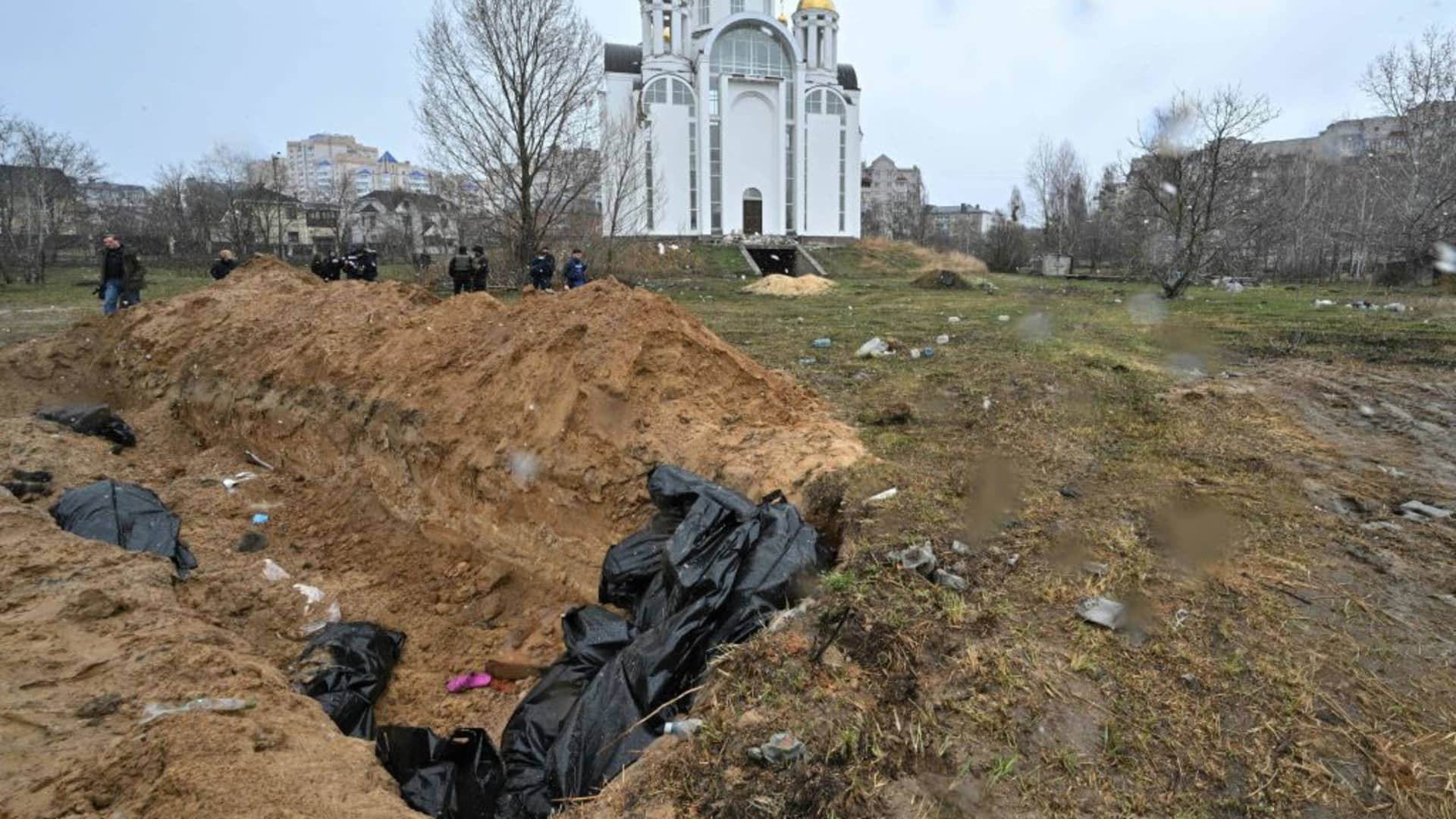 A mass grave is seen behind a church in the town of Bucha, northwest of the Ukrainian capital Kyiv on April 3, 2022.